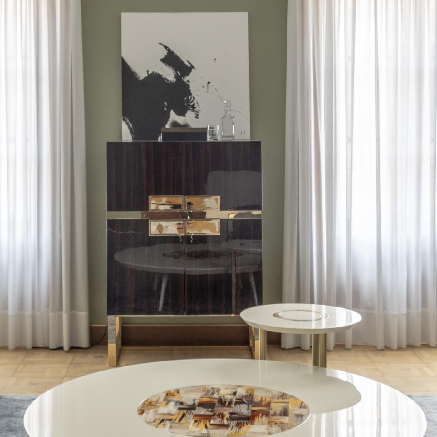 https://a.1stdibscdn.com/cosmopolitan-bar-cabinet-in-ebony-veneer-horn-gold-plated-brass-by-arcahorn-for-sale-picture-3/f_12192/f_492638921773758665665/Contenitori_e_librerie_Cosmopolitan_mobile_bar_in_ebano_Macassar_e_ottone_placcato_oro_24k_ambientata_Arcahorn_master.jpg