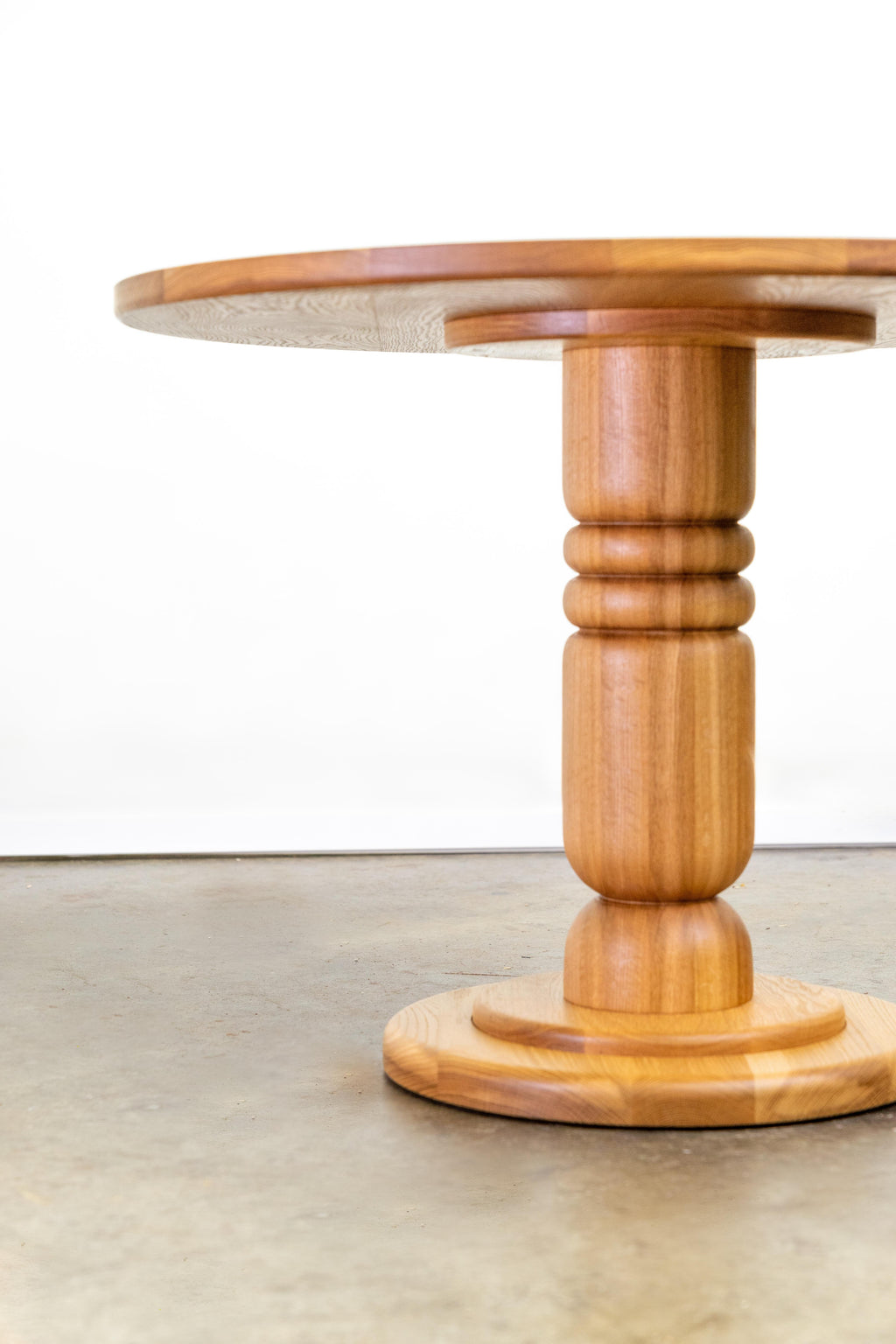 https://a.1stdibscdn.com/hand-turned-pedestal-table-in-solid-oak-or-walnut-for-sale-picture-2/f_106752/f_472556521761699173311/Storie_Collective_Round_Dining_Table_2_HiRes_master.jpg